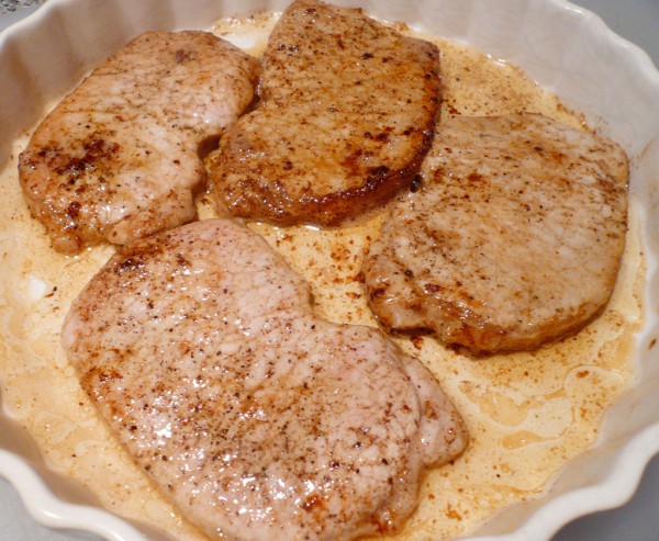 Seared pork cutlets in a pan for baking
